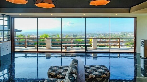 Une chambre moderne dotée d’une grande baie vitrée, d’une piscine et offrant une vue sur la ville.