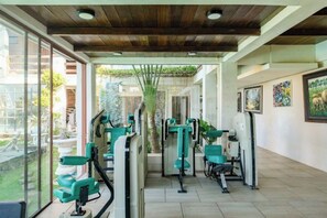 A gym with exercise equipment, a wooden ceiling, and a view of the outdoors. - The Lavana Villa Gajah Jimbaran (Bali)