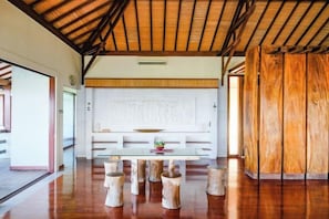 A spacious room with a wooden ceiling, a glass table, and a white bench. - The Lavana Villa Gajah Jimbaran (Bali)