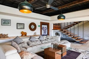 A modern living room with a glass coffee table, a sofa set, and a staircase with wooden steps. - The Lavana Villa Gajah Jimbaran (Bali)