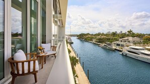 Ein Balkon mit Blick auf einen Yachthafen, mit Yachten und einer Stadtlandschaft im Hintergrund.
