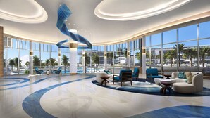 Eine geräumige Lobby mit gewölbter Decke, großen Fenstern und einem Poolbereich.