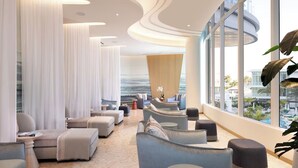 A modern lounge with seating, large windows, and a view of the outdoors. - Spacious Balcony Retreat Close to Fort Lauderdale Beach – Recharge in Modern Ele (Fort Lauderdale)