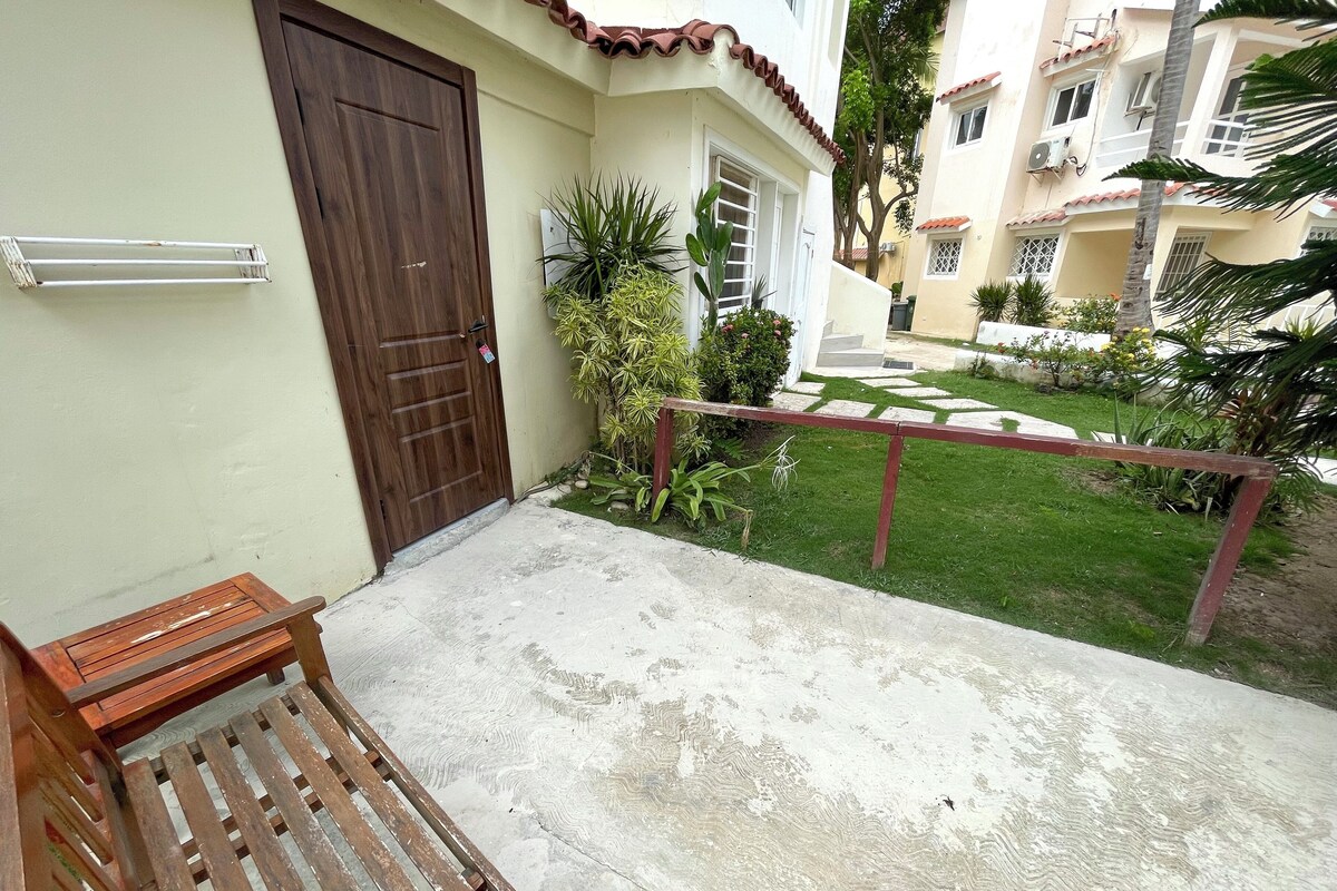 A wooden bench and a concrete patio area with a metal railing.