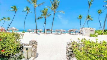 On the beach, white sand, sun loungers, beach umbrellas