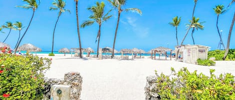 On the beach, white sand, sun-loungers, beach umbrellas
