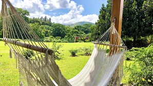 A hammock hanging between wooden posts in a lush garden with a clear sky. - CASAS DEL MAR HOTEL Beach & SPA (Punta Cana)
