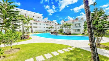 Ein Resort mit Schwimmbad, Palmen und blauem Himmel.