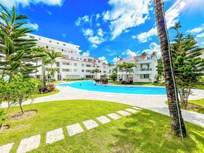 A resort with a swimming pool, palm trees, and a clear blue sky. - CASAS DEL MAR HOTEL Beach & SPA (Punta Cana)