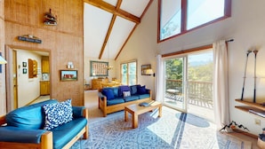 A spacious living area with a sofa, coffee table, and a dining area.