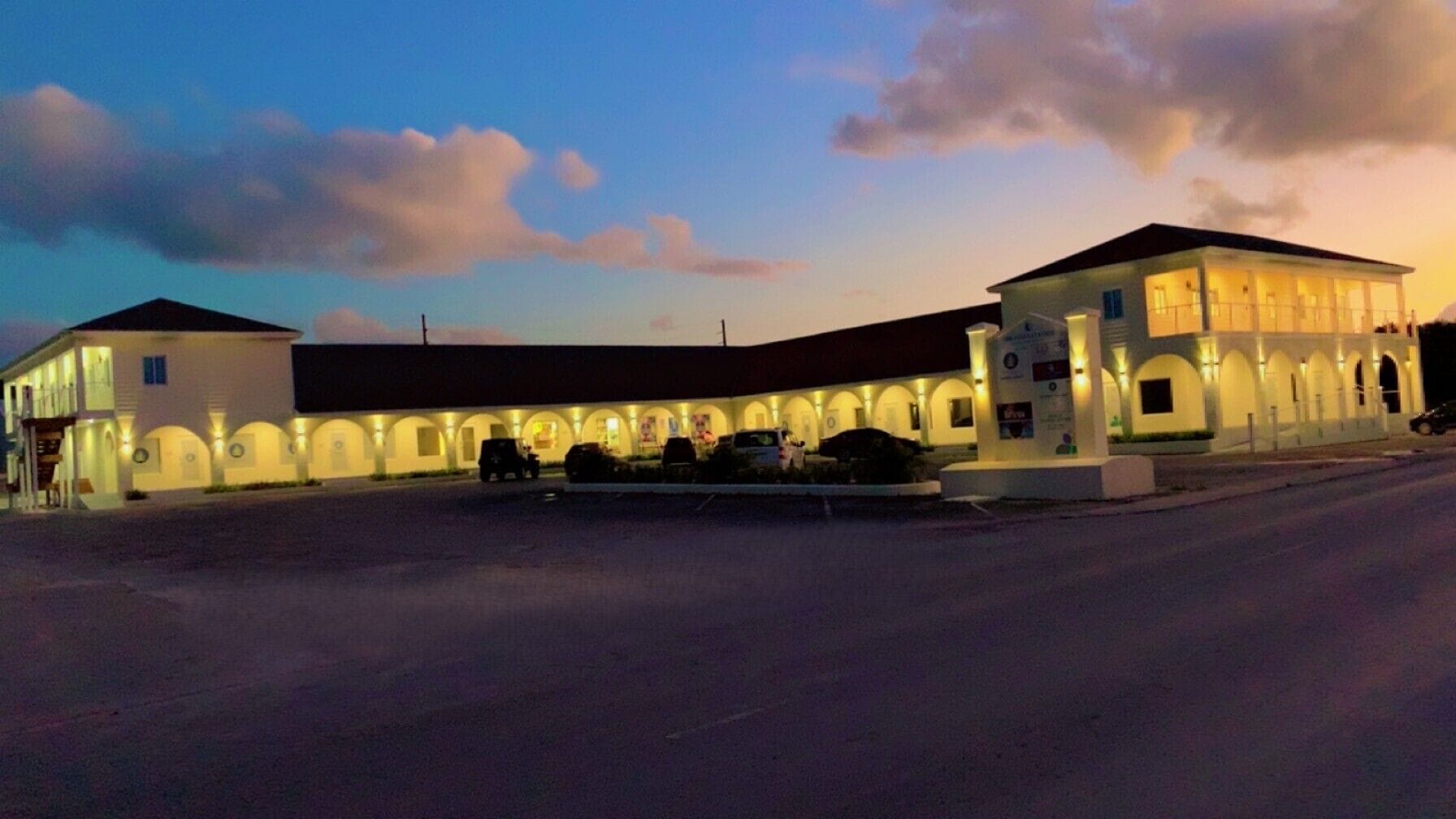 A large building with multiple balconies and a parking lot.