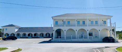A two-story building with a central courtyard, arched walkways, and a flat roof.