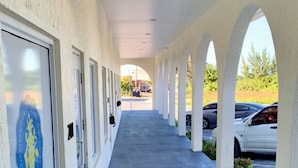 A covered walkway with a series of doors, each with a sign for the Department of Inland Revenue. - Town Center Abaco (Marsh Harbour)