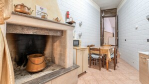 Eine Küche mit Kamin, Mikrowelle und Esstisch mit Stühlen.