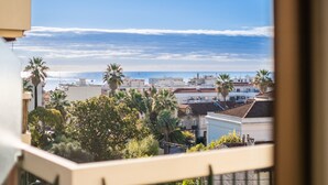 A coastal cityscape with buildings, palm trees, and the sea. - 3-Star Tourist Apartment with Sea View, Wi-Fi, and Air Conditioning (Golfe-Juan)