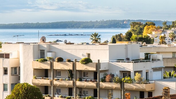 A coastal residential area with modern buildings, some with balconies, and a view of the sea. - 3-Star Tourist Apartment with Sea View, Wi-Fi, and Air Conditioning (Golfe-Juan)