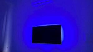 A room with a flat-screen TV mounted on the wall, a radiator, and a window with blinds. - Costantino Rooms (Rome)