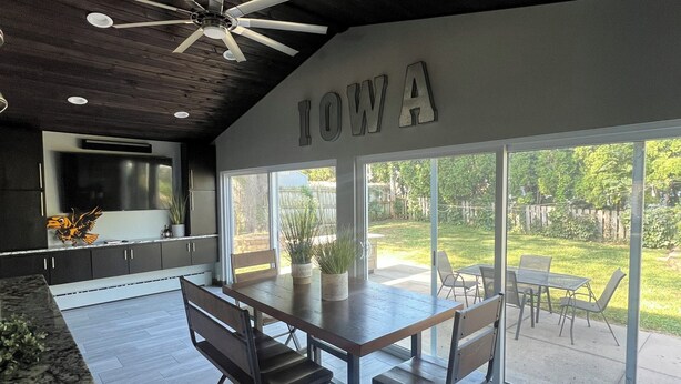 Una cocina moderna con comedor, ventilador de techo y una ventana grande con la palabra 'IOWA' en la pared.
