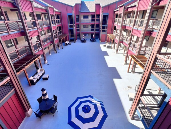A multi-level atrium with balconies, outdoor seating, and a central open space.