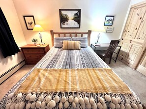 A bedroom with a bed, a nightstand, a desk, a chair, and a wardrobe. - Longbranch • 30+ day rental near Main St, Breck Slopes  and Trails (Breckenridge)