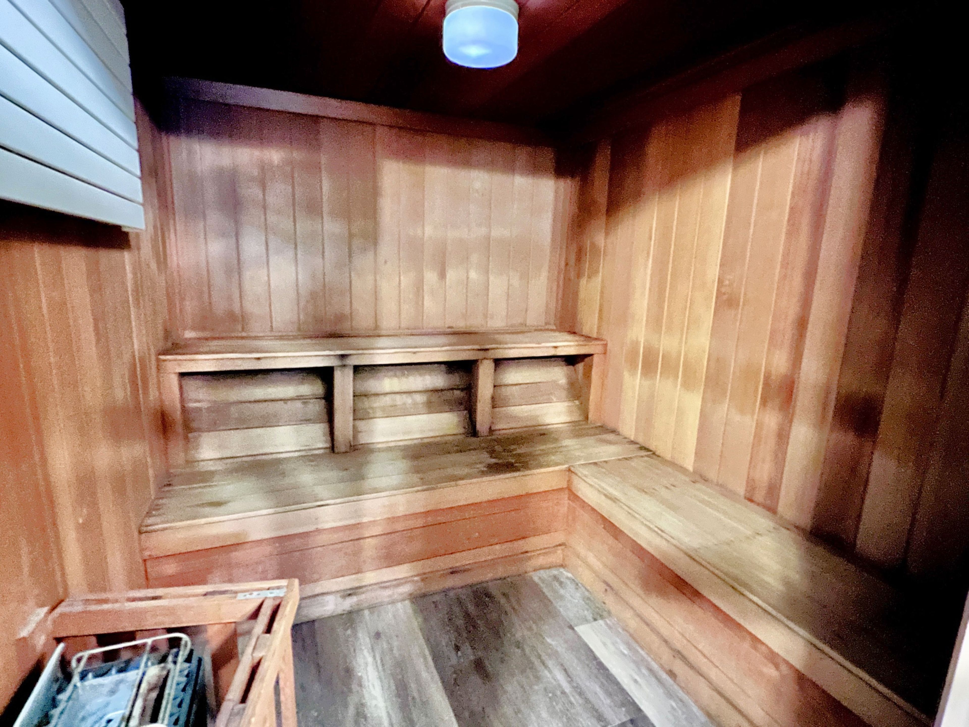 A sauna with wooden benches and a sloped floor.