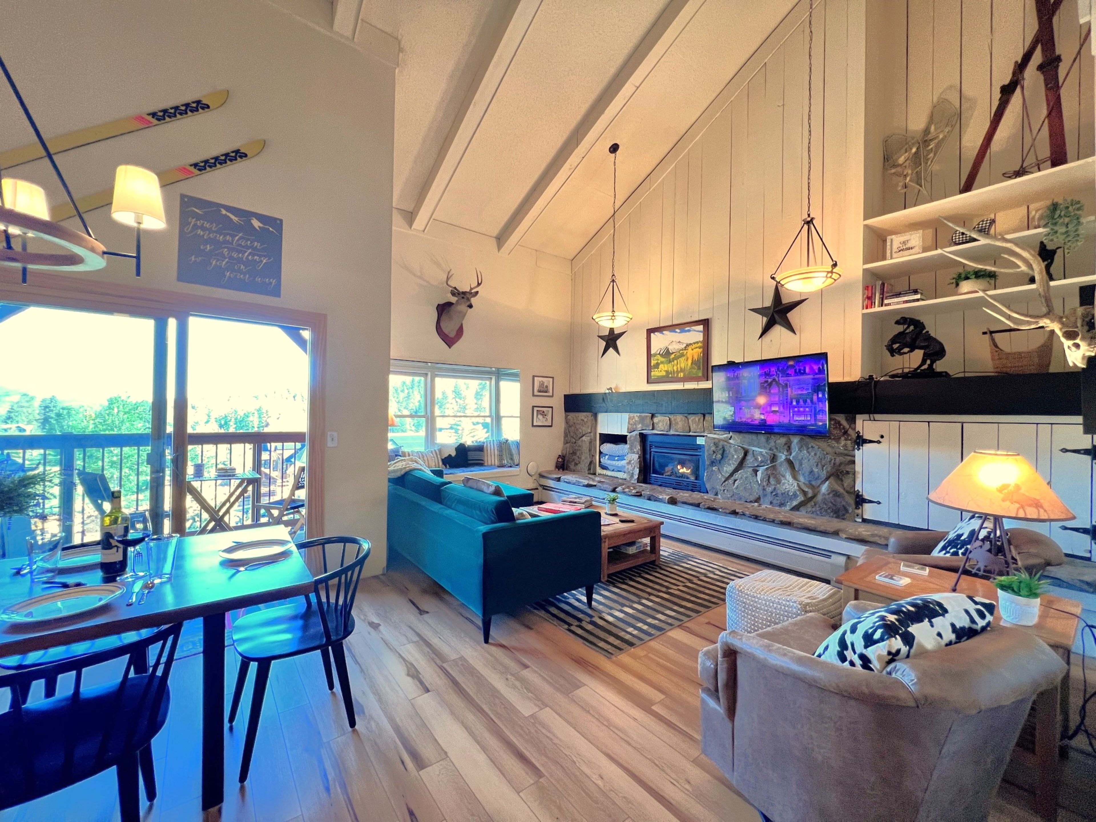 Un amplio espacio de estar con chimenea, asientos y televisor.