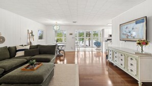 A spacious living room with a green sofa, a wooden coffee table, and a white cabinet with drawers. - Wild Sun Retreat- Waterfront, firepit, Kayak, lily pad, pet friendly with fee (Creal Springs)