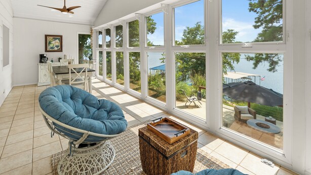 A spacious room with large windows, a ceiling fan, and a view of the outdoors. - Wild Sun Retreat- Waterfront, firepit, Kayak, lily pad, pet friendly with fee (Creal Springs)