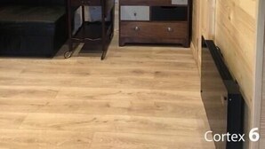 A wooden-paneled room with a sofa, a small table, and a dresser with drawers. - COSY STUDIO IN A QUIET LOCATION. NEAR A TUBE STATION. (Pinner)