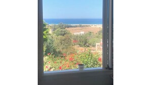A view from a window overlooking a coastal landscape with a clear sky. - Spacious one-bedroom apartment close to the sea (Tanger)