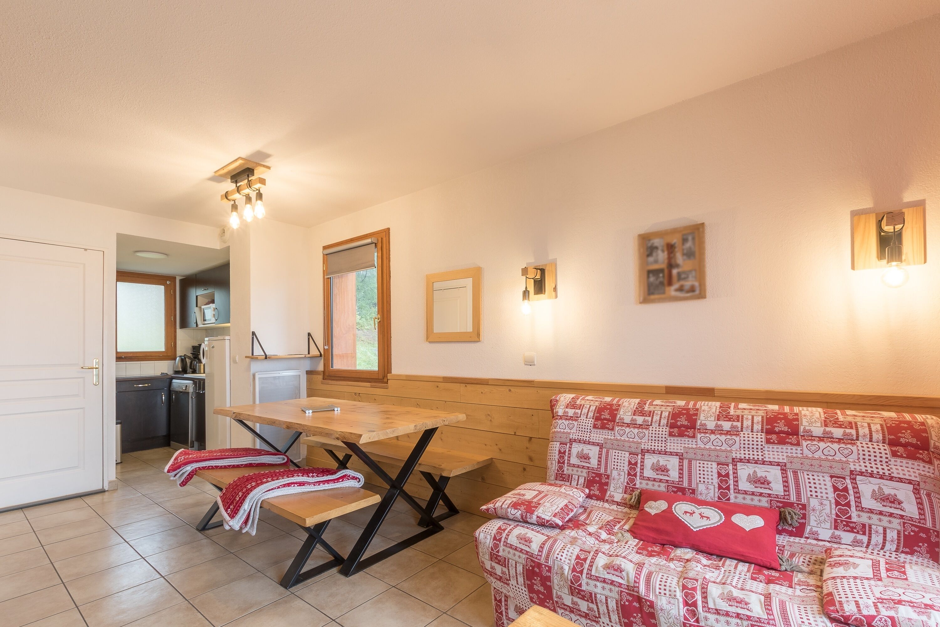 Un salon chaleureux avec un banc en bois, un canapé à motifs et une table à manger.