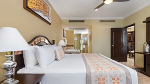 Una habitación de hotel con cama, mesita de noche, lámpara y ventilador de techo.
