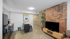 A compact living space with a kitchen, a dining area, and a seating area with a TV. - Cozy 1BR Near Findlay Market and UC, Rhinegeist (Cincinnati)