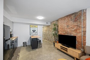 Een knus woongedeelte met een keuken, een eethoek en een zithoek met een televisie.