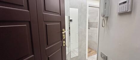 Una habitación de hotel moderna con una puerta de madera, un teléfono y un interruptor de luz en la pared.