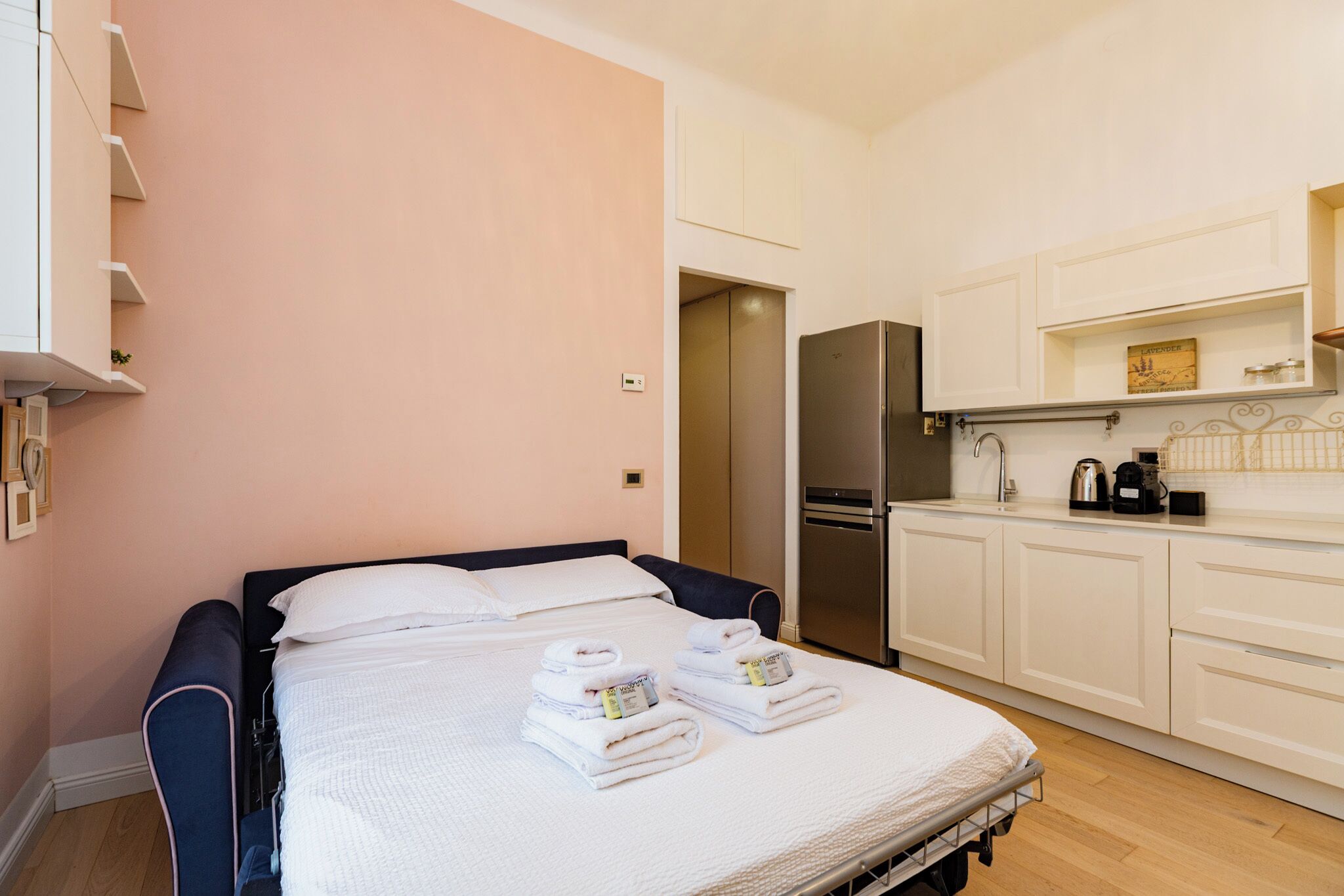 Ein Schlafzimmer mit Bett, Kleiderschrank, einer Küchenzeile und einem Badezimmer.