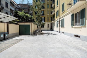 A courtyard with a green gate, a bicycle, and a trash bin. - Brioschi88 Nice, quiet and peaceful by Hospity (Milano)