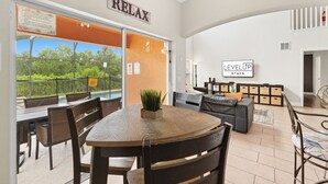 A spacious room with a dining area, a sofa, and a sign that reads 'RELAX'.