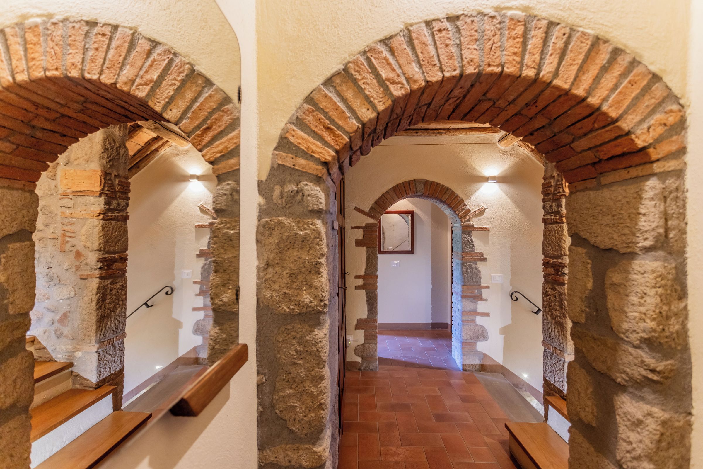 A corridor with stone walls and wooden benches.