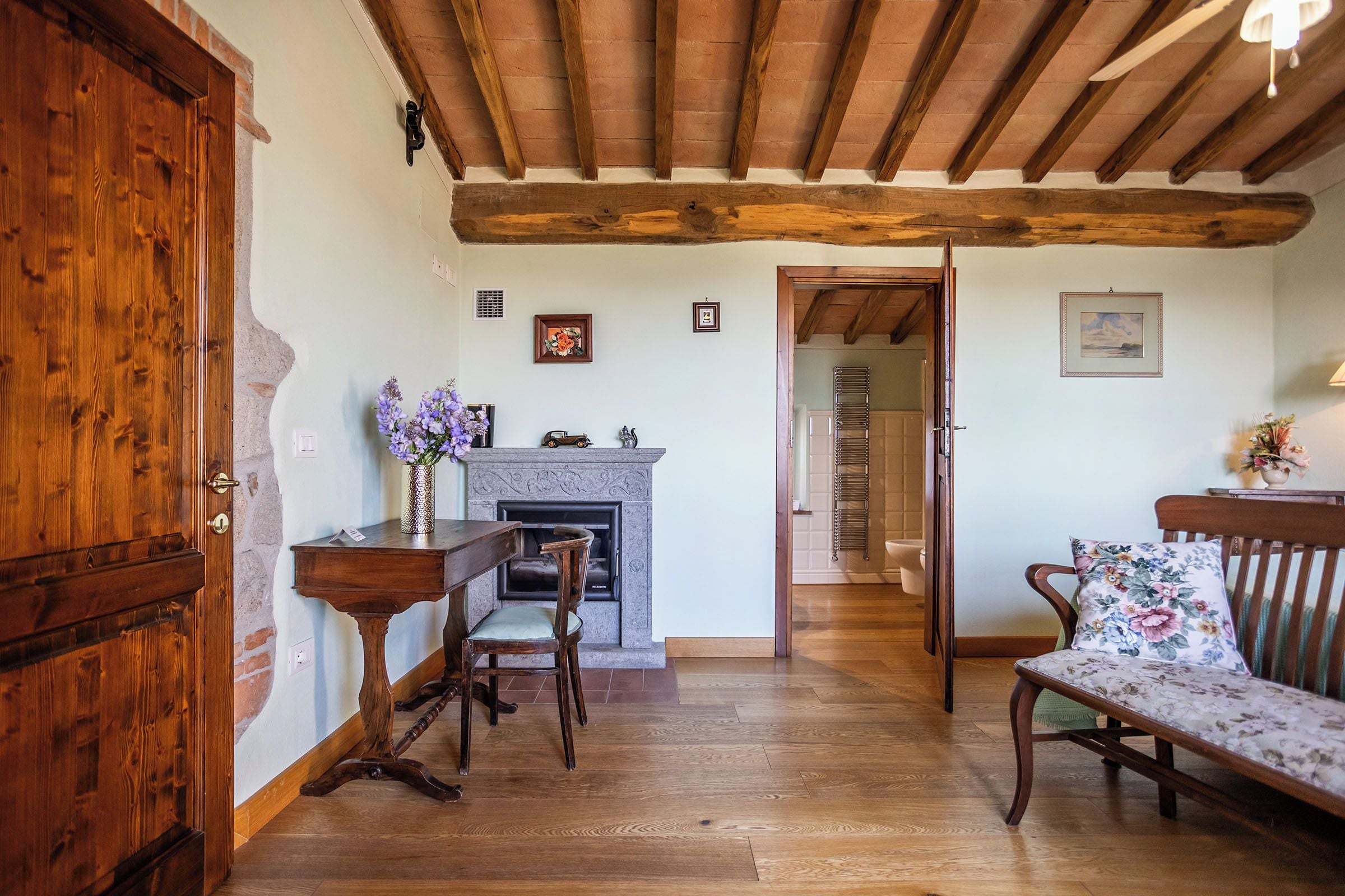 A room with a fireplace, wooden furniture, and a door.