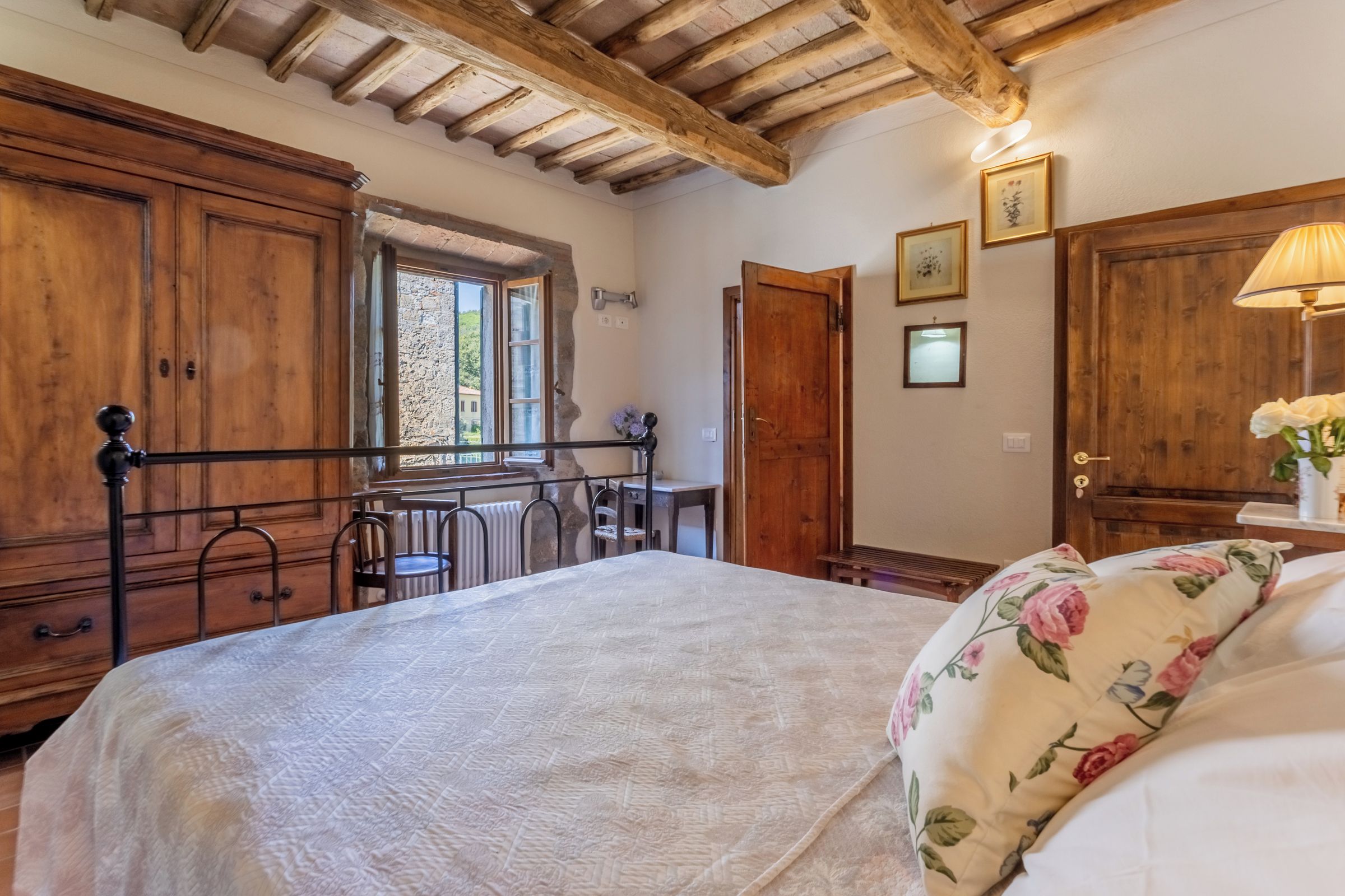 Une chambre à coucher avec un lit, une armoire en bois et un bureau avec une chaise.