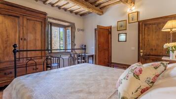 Une chambre à coucher avec un lit, une armoire en bois et un bureau avec une chaise.