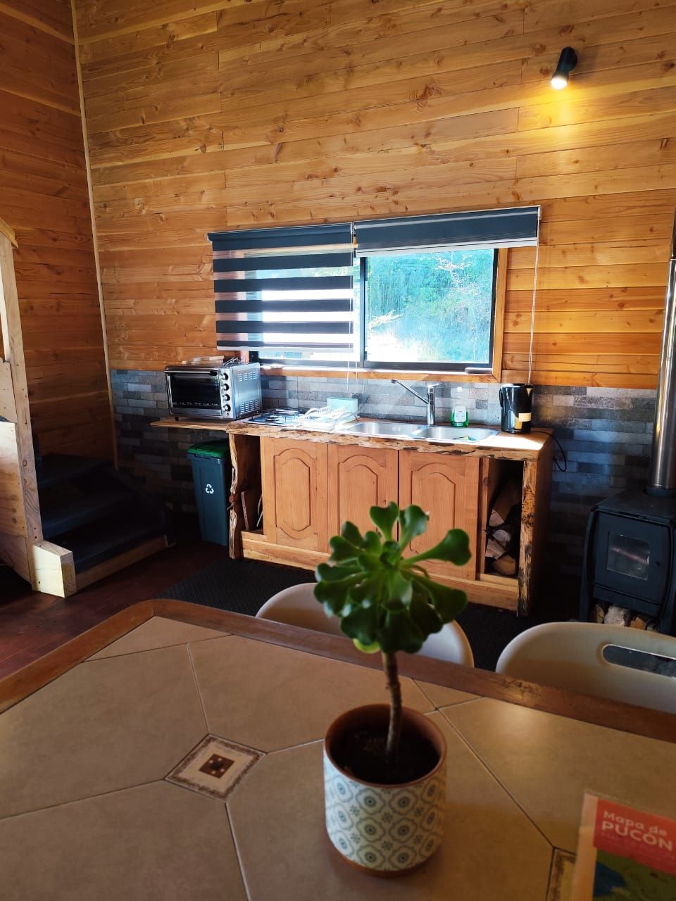 A wooden interior with a kitchen area, including a stove, microwave, and cabinets.