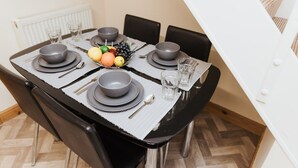 A dining table set with plates, bowls, cutlery, and a fruit bowl. - Stunning House in Heart of Historic Lincoln (Lincolnshire)