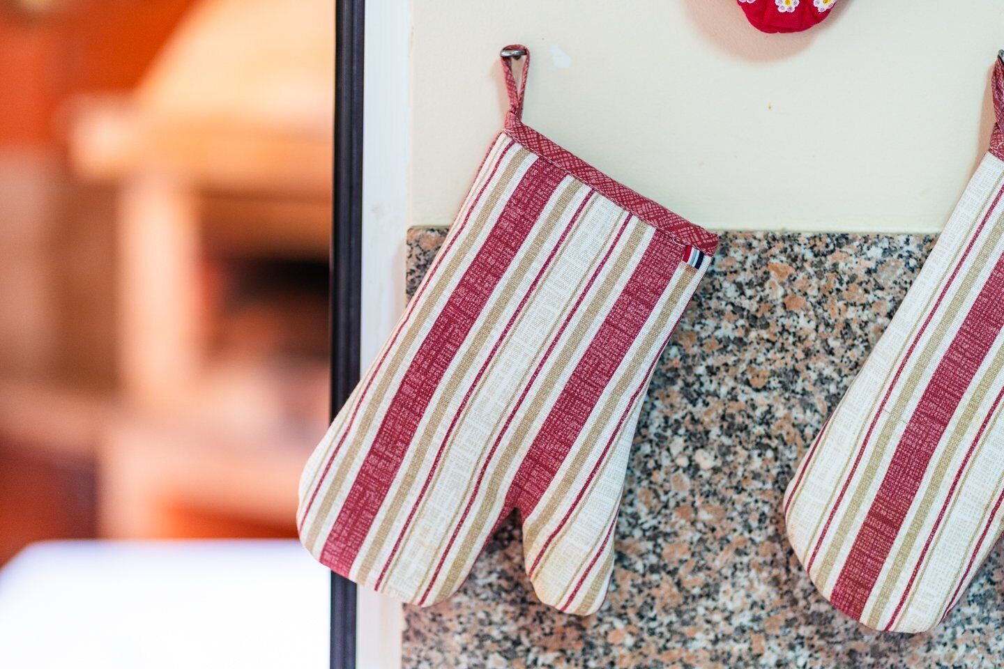 Una cucina con due strofinacci a righe appesi a un portasciugamani.