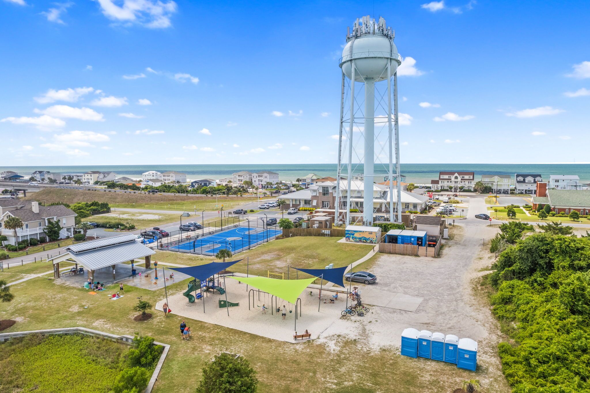 Una torre de agua, una cancha de baloncesto y un aparcamiento con vistas a la playa.