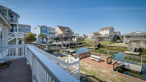 Zona residencial costera con casas, un muelle y una pequeña masa de agua.