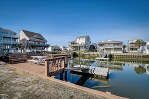 A waterfront property with a dock, a wooden deck, and a marina. - Beautiful Canal front home. Just a short walk to the beach! (Holden Beach)