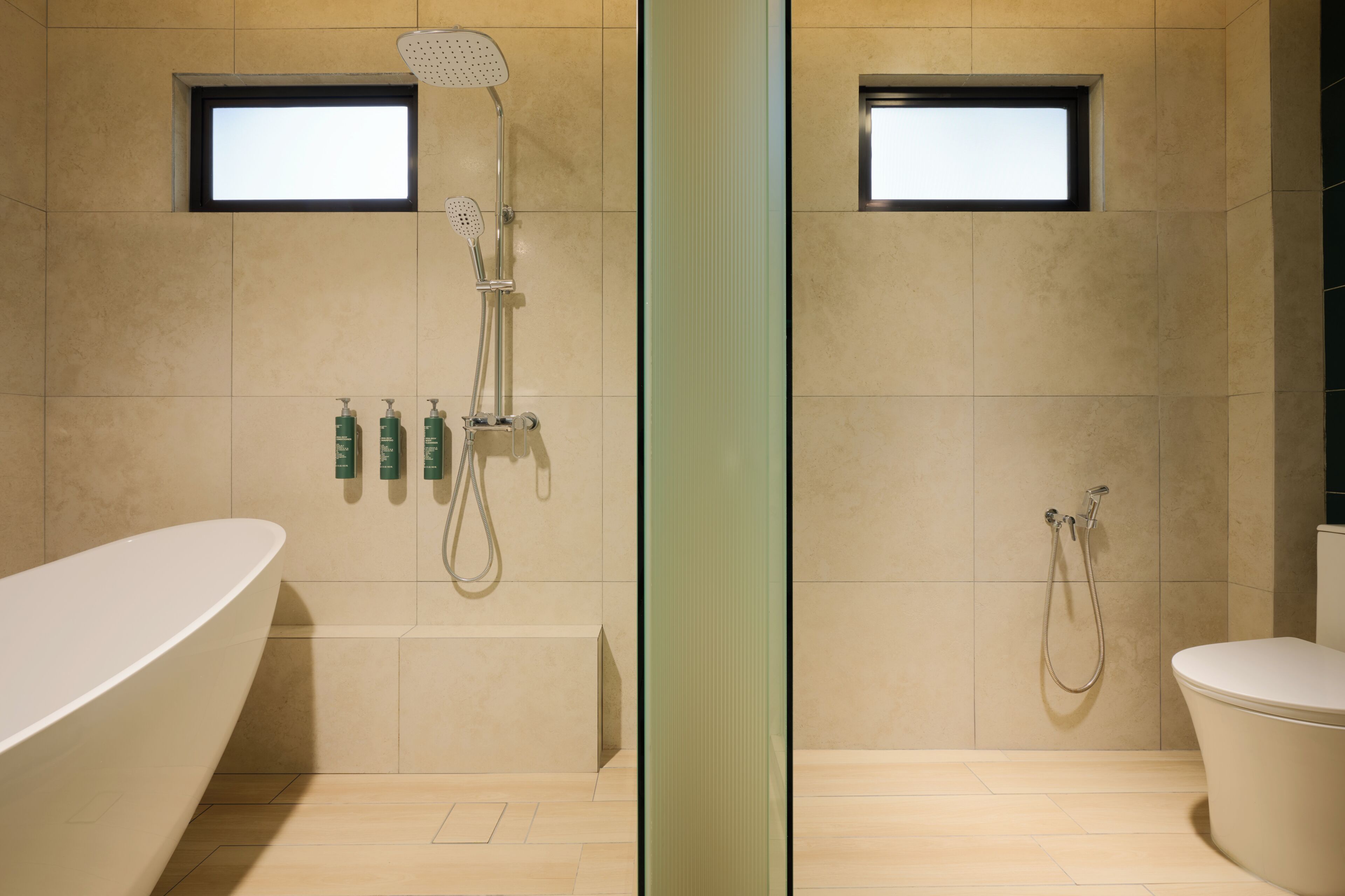 A modern bathroom with a freestanding bathtub, a glass-enclosed shower area, and a toilet.