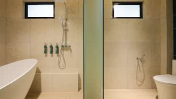 A modern bathroom with a freestanding bathtub, a glass-enclosed shower area, and a toilet.